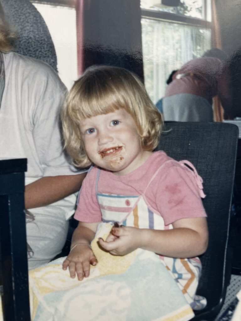 Caroline als klein meisje, zichtbaar aan het smullen van iets met chocolade